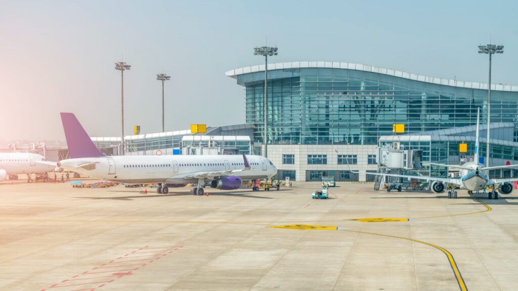 Schiphol terminal met geparkeerde vliegtuigen en moderne glazen gevel, een van de grote gebouwen in Nederland
