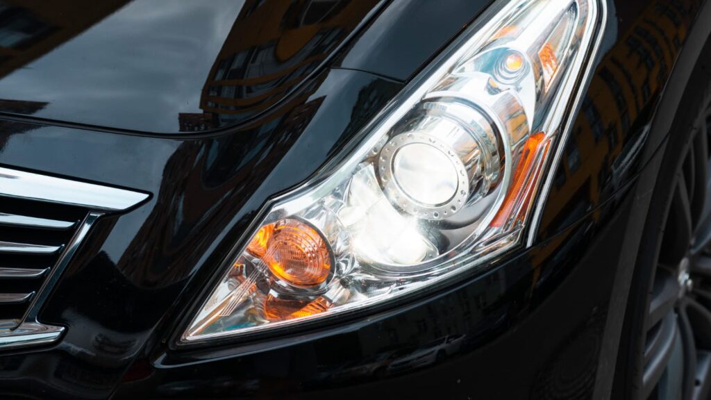 Close-up van een moderne autokoplamp in een glanzend zwarte auto voor meer rijplezier