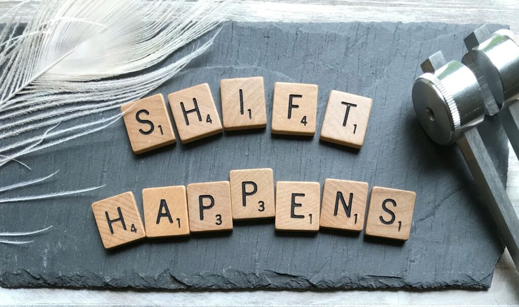Scrabbleletters vormen de tekst "Shift Happens", symbool voor persoonlijke groei met een life coach