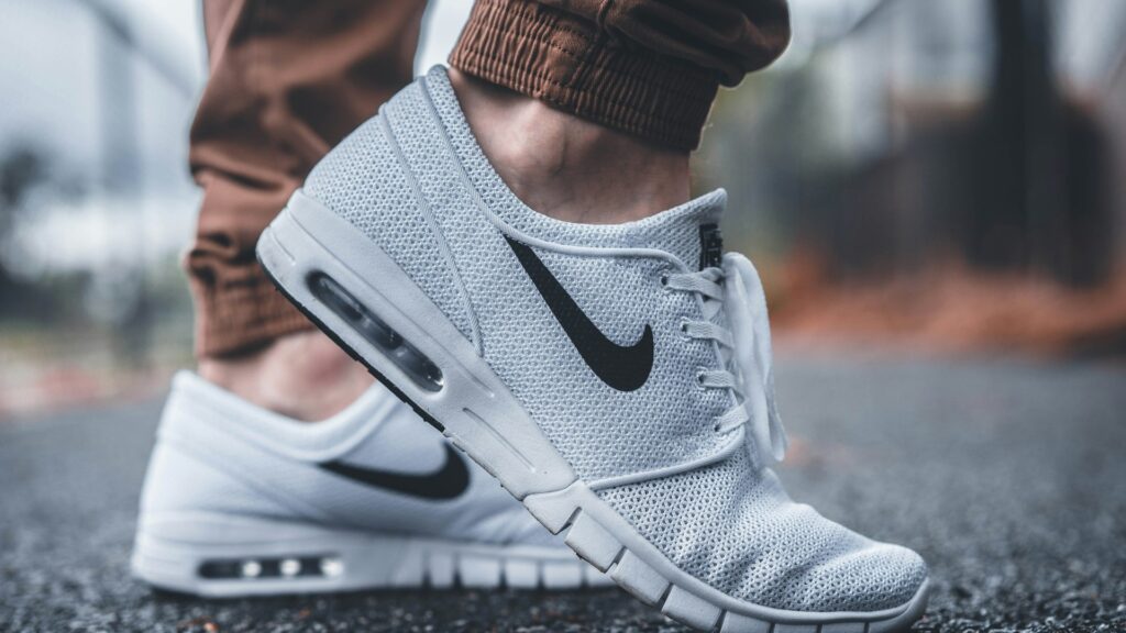 Close-up van witte Nike sneakers met zichtbare Air-zool, gedragen op straat