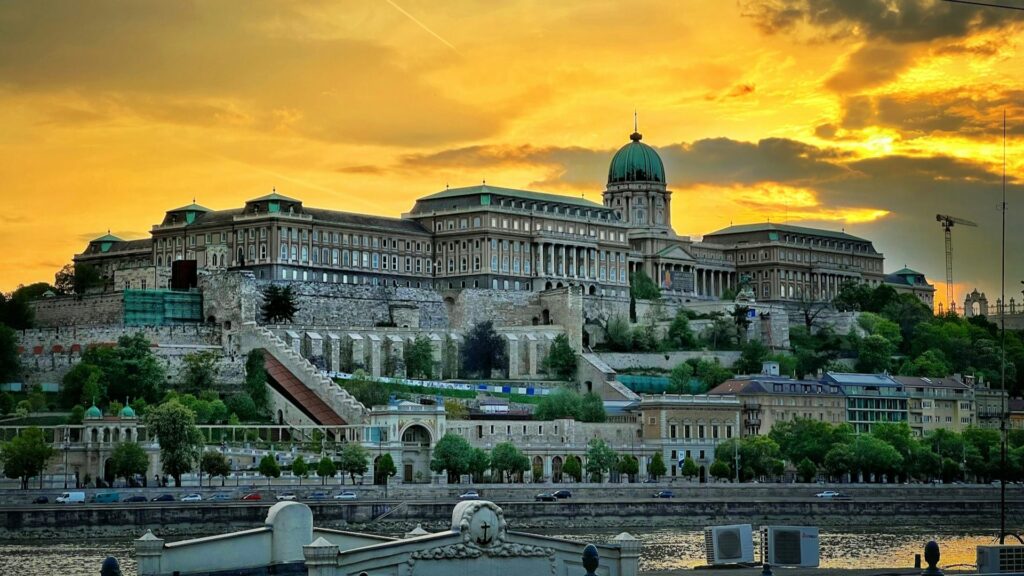 Buda Castle in Hongarije, gelegen op een heuvel boven de Donau, bij zonsondergang met warme luchtkleuren