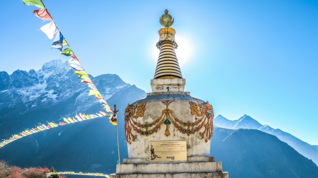 Boeddhistische stupa met gebedsvlaggen en Himalaya op de achtergrond