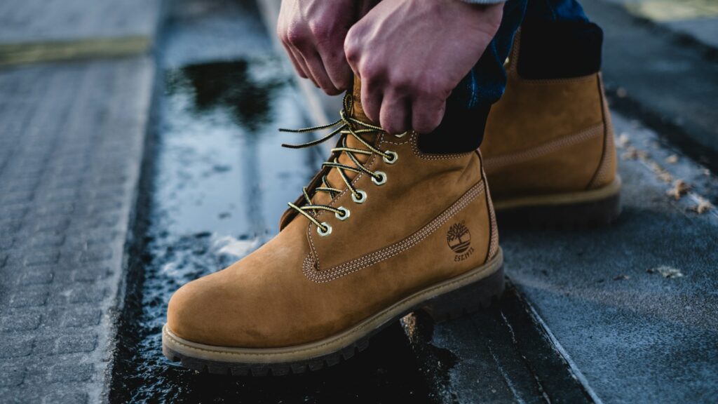 Persoon strikt iconische gele Timberland boots boven natte stoep