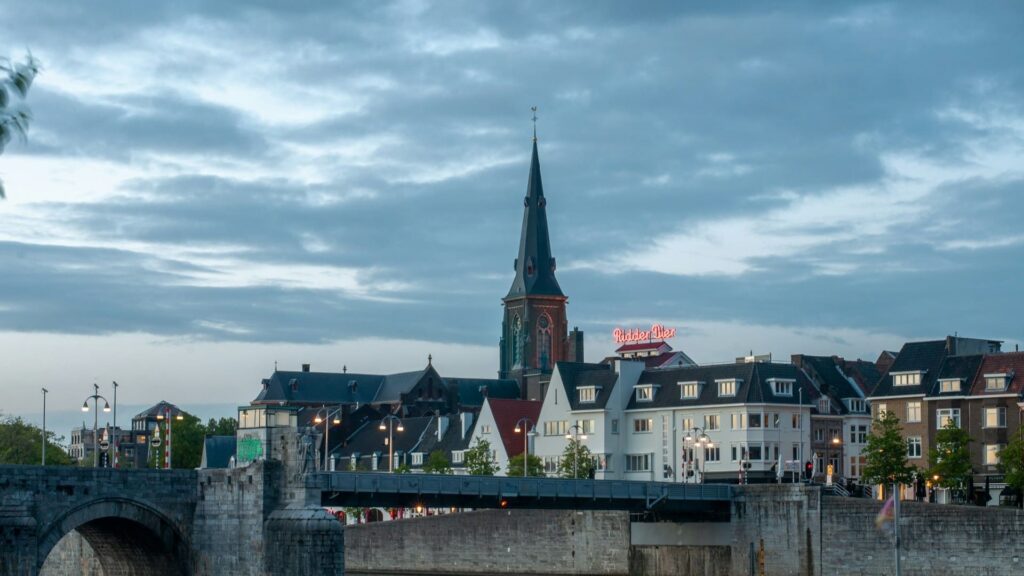 Historisch stadscentrum van studentenstad Maastricht met kerk en brug bij schemering