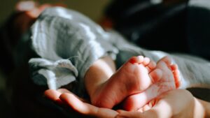 Babyvoetjes in de hand van een ouder, symbool voor de zorg en warmte van goede babyproducten